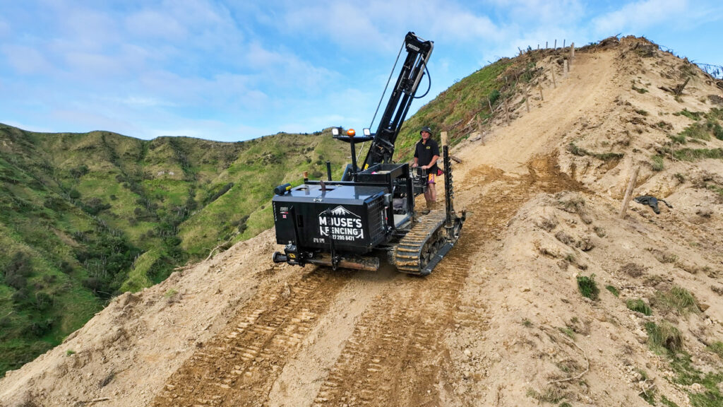 Fencing machine rolling down a dirt hill with chaingrip attachments