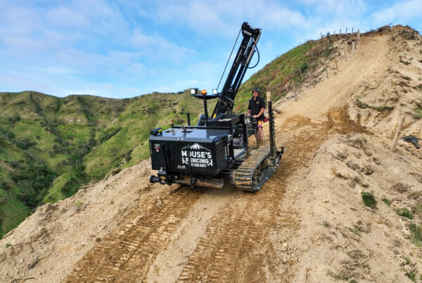 Fencing machine rolling down a dirt hill with chaingrip attachments